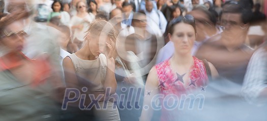 Crowd of people walking on city street - motion blurred image with unrecognizable faces - Young woman standing still, feeling down, depressed Crowd of people walking on city street - motion blurred image with unrecognizable faces - Young woman standing still, feeling down, depressed