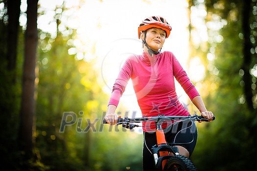 Pretty, young woman biking on a mountain bike enjoying healthy active lifestyle outdoors in summer (shallow DOF) Pretty, young woman biking on a mountain bike enjoying healthy active lifestyle outdoors in summer (shallow DOF)