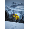 Young man snowshoeing in high mountains, enjoying splendid winter weather with abundance of snow