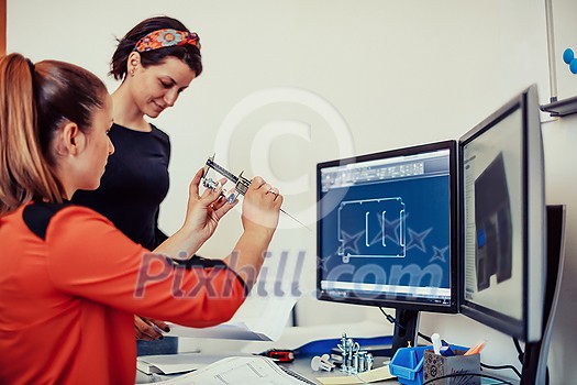 Within the heavy industry, a factory industrial engineer measures with a caliper and on a personal computer Designs a 3D model. High quality photo Within the heavy industry, a factory industrial engineer measures with a caliper and on a personal computer Designs a 3D model. High quality photo