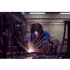 Professional Heavy Industry Welder Working Inside the factory, Wears Helmet and Starts Welding. Selective Focus. High-quality photo