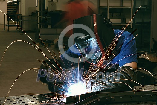 Professional Heavy Industry Welder Working Inside the factory, Wears Helmet and Starts Welding. Selective Focus. High-quality photo Professional Heavy Industry Welder Working Inside the factory, Wears Helmet and Starts Welding. Selective Focus. High-quality photo