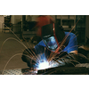 Professional Heavy Industry Welder Working Inside the factory, Wears Helmet and Starts Welding. Selective Focus. High-quality photo