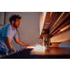Within heavy industry. A man works in a modern factory on a CNC machine. Selective focus. High-quality photo