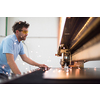 Within heavy industry. A man works in a modern factory on a CNC machine. Selective focus. High-quality photo