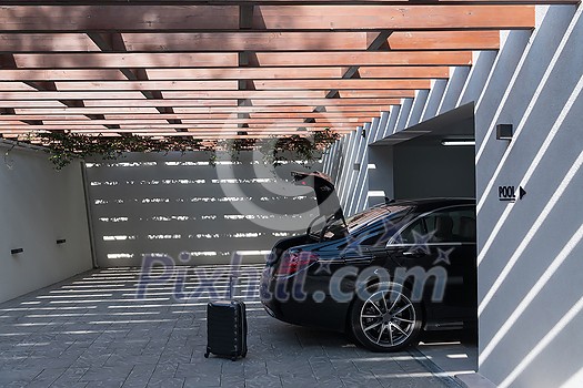 A photo of a suitcase standing next to a car in a luxury garage. High-quality photo A photo of a suitcase standing next to a car in a luxury garage. High-quality photo
