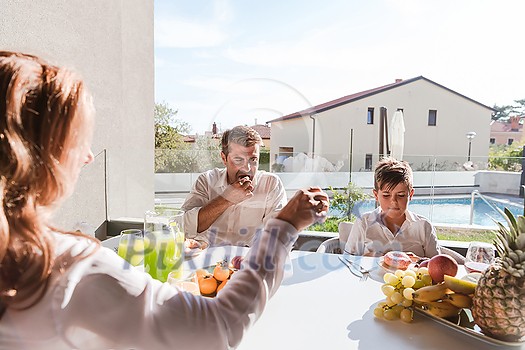 The senior couple and their son eating a healthy breakfast together early in the morning in a luxury house. Selective focus. High-quality photo The senior couple and their son eating a healthy breakfast together early in the morning in a luxury house. Selective focus. High-quality photo