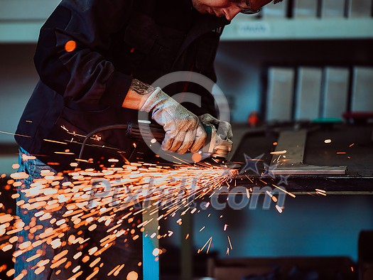 Heavy Industry Engineering Factory Interior with Industrial Worker Using Angle Grinder and Cutting a Metal Tube. Contractor in Safety Uniform and Hard Hat Manufacturing Metal Structures. High-quality photo Heavy Industry Engineering Factory Interior with Industrial Worker Using Angle Grinder and Cutting a Metal Tube. Contractor in Safety Uniform and Hard Hat Manufacturing Metal Structures. High-quality photo