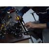 Industrial worker man soldering cables of manufacturing equipment in a factory. Selective focus. High quality photo