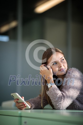 Pretty, young female student in front of a blackboard during class Pretty, young female student in front of a blackboard during class