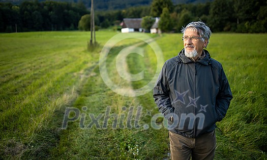 Senior man enjoying the outdoors, hiking, walking through lovely nature Senior man enjoying the outdoors, hiking, walking through lovely nature