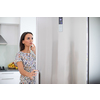 Pretty, young woman in her modern kitchen, by the fridge, about to cook a healthy meel for her family (color toned image)