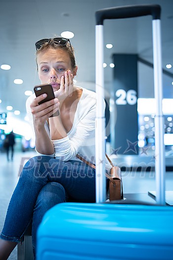 Young woman with her luggage at an international airport, before going through the check-in and the security check before her flight Young woman with her luggage at an international airport, before going through the check-in and the security check before her flight