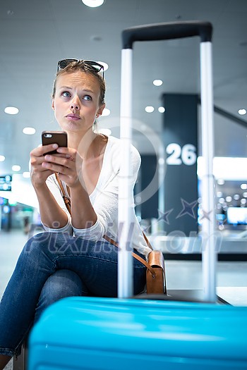 Young woman with her luggage at an international airport, before going through the check-in and the security check before her flight Young woman with her luggage at an international airport, before going through the check-in and the security check before her flight