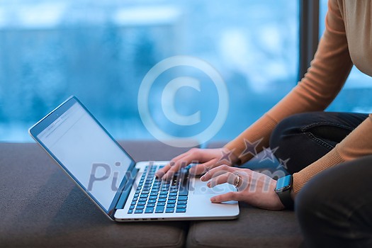 A young woman sitting in a modern space while working on a project on a laptop. Selective focus . High-quality photo A young woman sitting in a modern space while working on a project on a laptop. Selective focus . High-quality photo