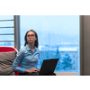 A young woman sitting in a modern space while working on a project on a laptop. Selective focus . High-quality photo