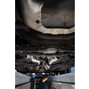 Car mechanic under a car in a repair shop/car garage (shallow DOF/color toned image)