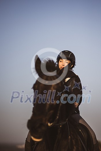 Female horse rider riding outdoors on her lovely horse Female horse rider riding outdoors on her lovely horse