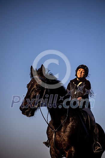 Female horse rider riding outdoors on her lovely horse Female horse rider riding outdoors on her lovely horse