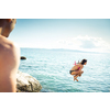 Young man having fun and taking a dive in the sea