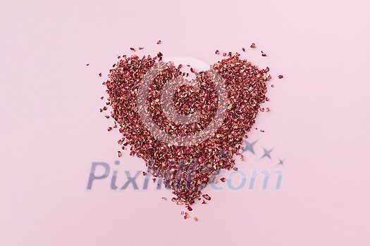 Dried red rose petals in shape of heart on toned background, flat lay with place for text. Minimal Valentine's day card design. Dried red rose petals in shape of heart on toned background, flat lay with place for text. Minimal Valentine's day card design.