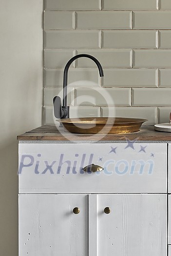 White cabinets of an old residential house with gray tiles wall, white cabinets, old copper sink in comfortable small kitchen on wooden counter. Country house kitchen concept. White cabinets of an old residential house with gray tiles wall, white cabinets, old copper sink in comfortable small kitchen on wooden counter. Country house kitchen concept.