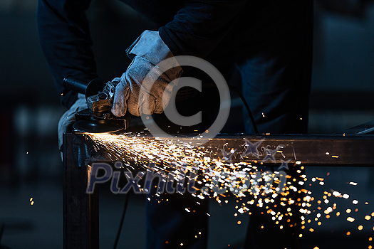 Man working on iron with grinder. Man at work. Sparkles and fire from grinder cutting. Grinder. Worker. Man working on iron with grinder. Man at work. Sparkles and fire from grinder cutting. Grinder. Worker.
