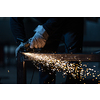 Man working on iron with grinder. Man at work. Sparkles and fire from grinder cutting. Grinder. Worker.