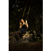 Carefree woman enjoying summer. Young woman is swinging on a swing in summer park garden.