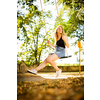 Carefree woman enjoying summer. Young woman is swinging on a swing in summer park garden.