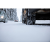 Car on a snowy winter road amid forests - using its four wheel drive capacities to get through the snow