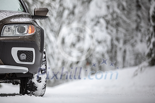 Car on a snowy winter road amid forests - using its four wheel drive capacities to get through the snow Car on a snowy winter road amid forests - using its four wheel drive capacities to get through the snow