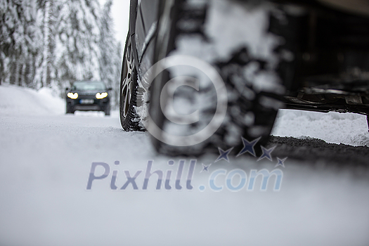 Car on a snowy winter road amid forests - using its four wheel drive capacities to get through the snow Car on a snowy winter road amid forests - using its four wheel drive capacities to get through the snow
