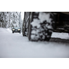 Car on a snowy winter road amid forests - using its four wheel drive capacities to get through the snow