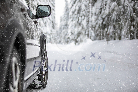 Car on a snowy winter road amid forests - using its four wheel drive capacities to get through the snow Car on a snowy winter road amid forests - using its four wheel drive capacities to get through the snow