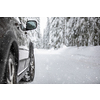 Car on a snowy winter road amid forests - using its four wheel drive capacities to get through the snow