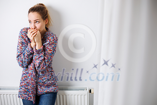 Cold, depressed mid-aged woman at home feeling sad, lonely, anxious about energy prices going up (color toned image) Cold, depressed mid-aged woman at home feeling sad, lonely, anxious about energy prices going up (color toned image)