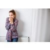 Cold, depressed mid-aged woman at home feeling sad, lonely, anxious about energy prices going up (color toned image)