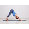 Woman doing Ashtanga Vinyasa yoga Surya Namaskar Sun Salutation asana Adhomukha svanasana - downward facing dog on yoga mat in studio on grey bagckground