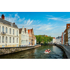 Tourist boat in canal between old houses. Brugge Bruges, Belgium