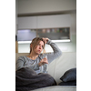 Midlle aged woman at home with a bottle of strong alcohol in her hands