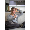 Midlle aged woman at home with a bottle of strong alcohol in her hands