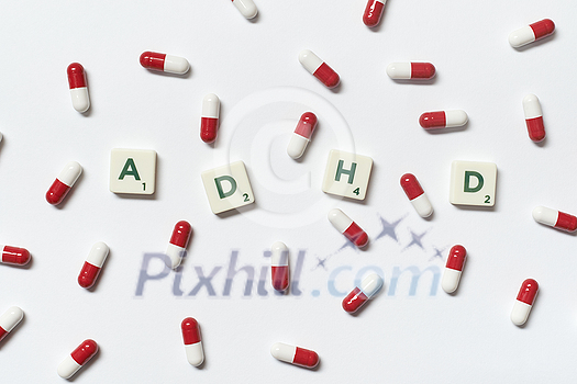 ADHD word formed of scrabble blocks and pharmaceutical tablets over white background. Attention deficit hyperactivity disorder and mental health awareness. ADHD word formed of scrabble blocks and pharmaceutical tablets over white background. Attention deficit hyperactivity disorder and mental health awareness.