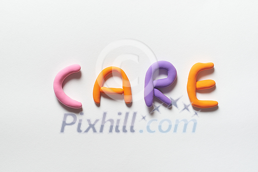 Care word formed of colored plasticine on white backdrop. Care word formed of colored plasticine on white backdrop.
