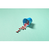 Pharmaceutical tablets falling out of bucket over touquose background. Flat lay with copy space.