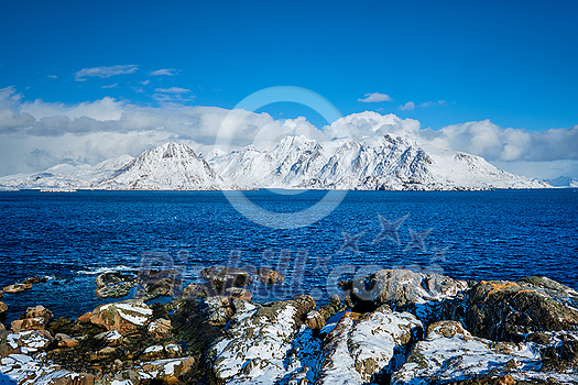 Lofoten islands and Norwegian sea in winter with snow covered mountains. Lofoten islands, Norway Lofoten islands and Norwegian sea in winter with snow covered mountains. Lofoten islands, Norway