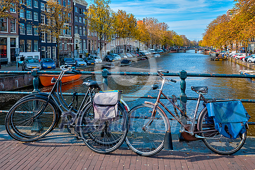Amterdam cityscape with canal, bridge with bicycles and medieval houses. Amsterdam, Netherlands Amterdam cityscape with canal, bridge with bicycles and medieval houses. Amsterdam, Netherlands