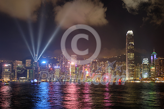 Hong Kong skyline cityscape downtown skyscrapers over Victoria Harbour in the evening illuminated with lasers with tourist boat ferries . Hong Kong, China Hong Kong skyline cityscape downtown skyscrapers over Victoria Harbour in the evening illuminated with lasers with tourist boat ferries . Hong Kong, China