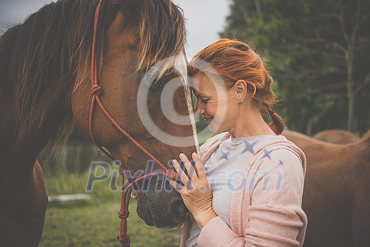 Pretty, young, redhead woman with her lovely horse, during her favorite leisure Pretty, young, redhead woman with her lovely horse, during her favorite leisure