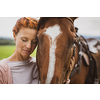 Pretty, young, redhead woman with her lovely horse, during her favorite leisure